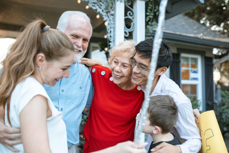 Happy multigenerational family celebrating together outside their new home